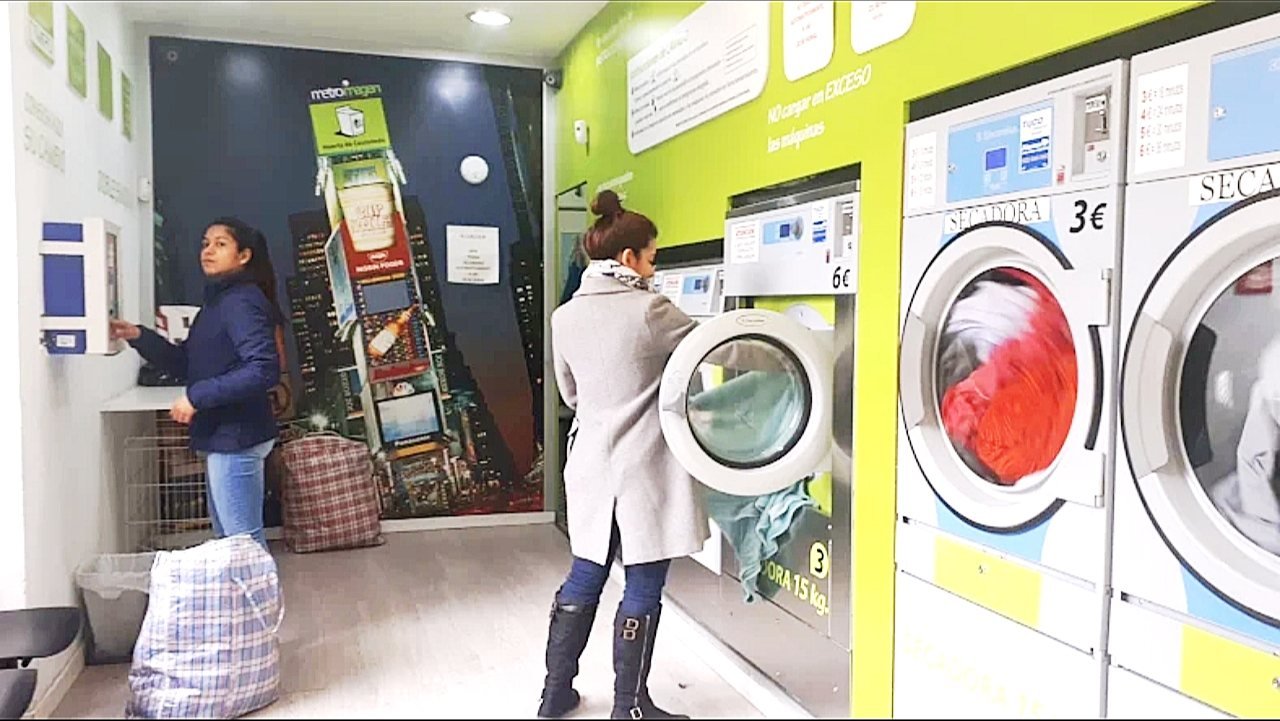 Clientas cargando la ropa en las lavadoras de Colada Exprés
